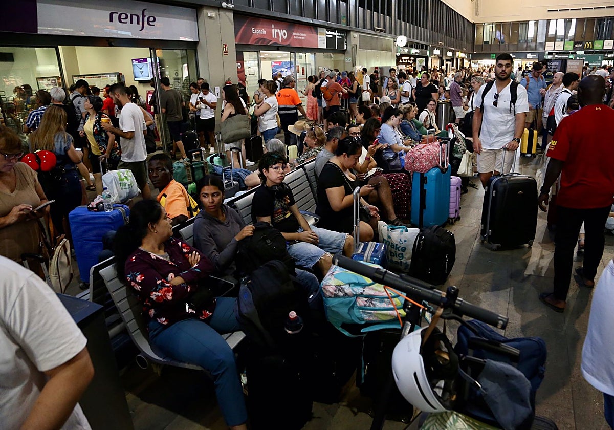 Los viajeros esperan en la estación a la llegada de sus trenes.