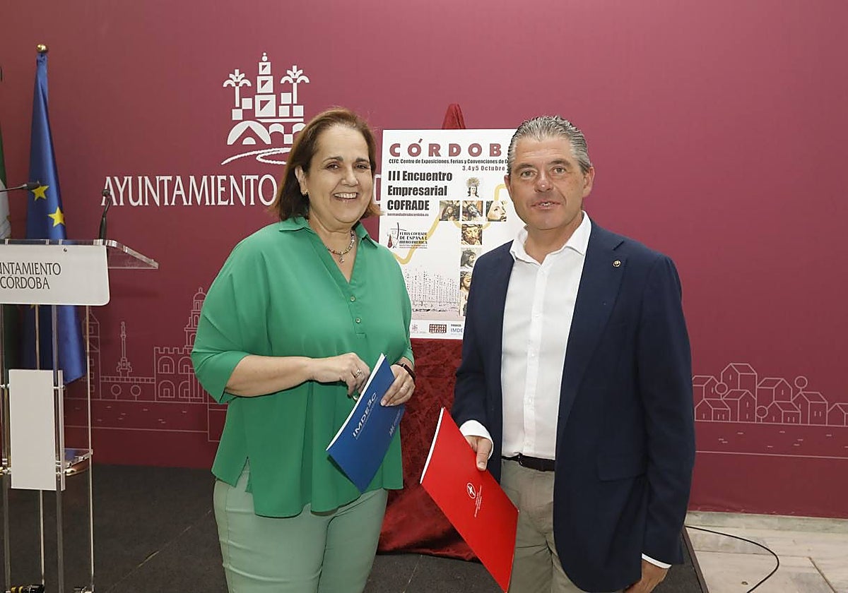 Blanca Torrent y Manuel Murillo, junto al cartel de la tercera edición del Encuentro Empresarial Cofrade de Córdoba, este miércoles