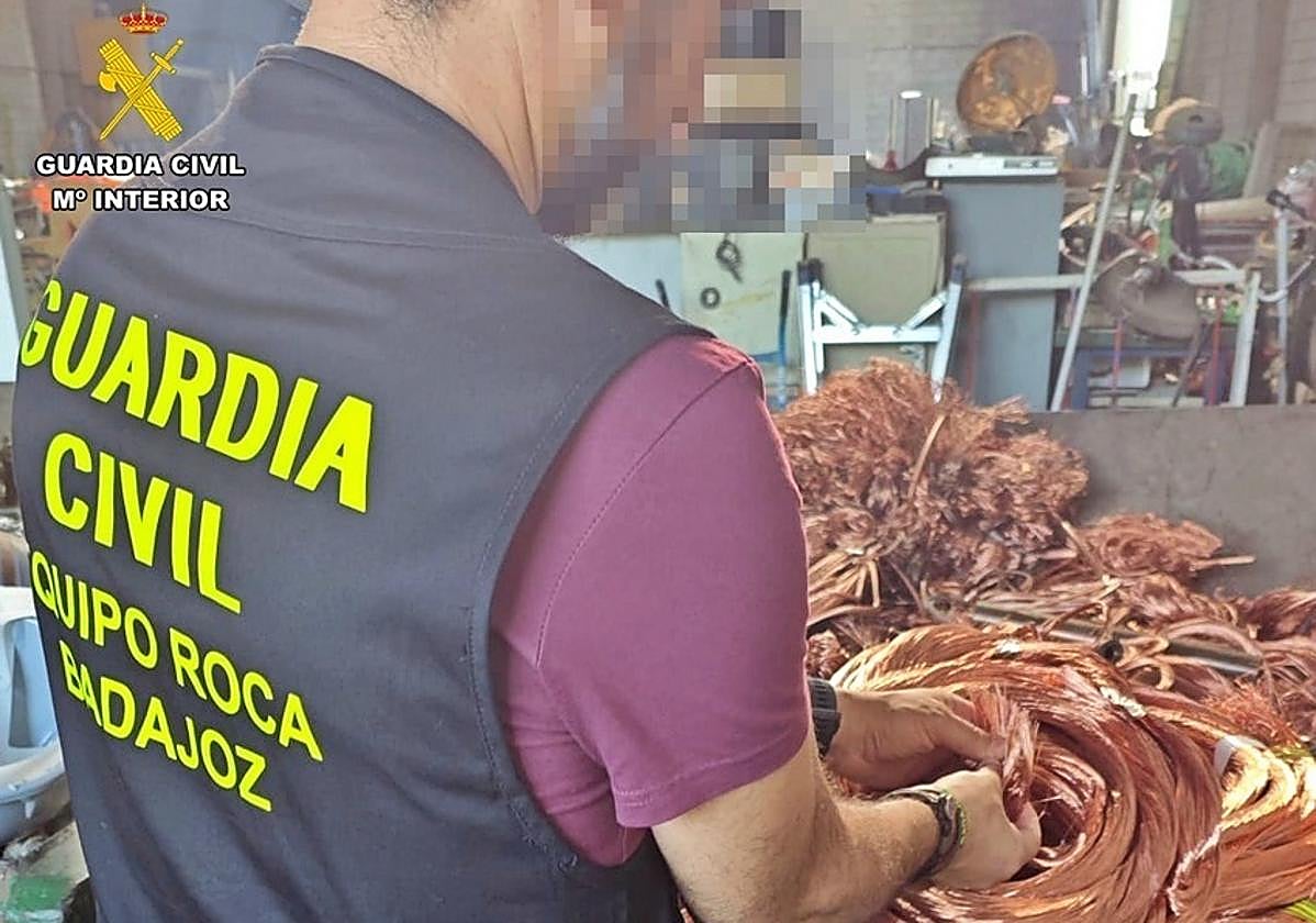 Un agente de la Guardia Civil recupera los metros de cables robados.