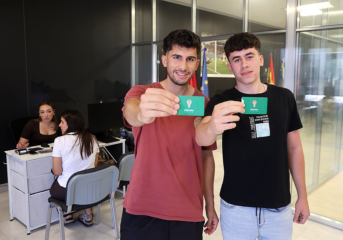 Dos aficionados del Córdoba CF con su abono para la nueva temporada