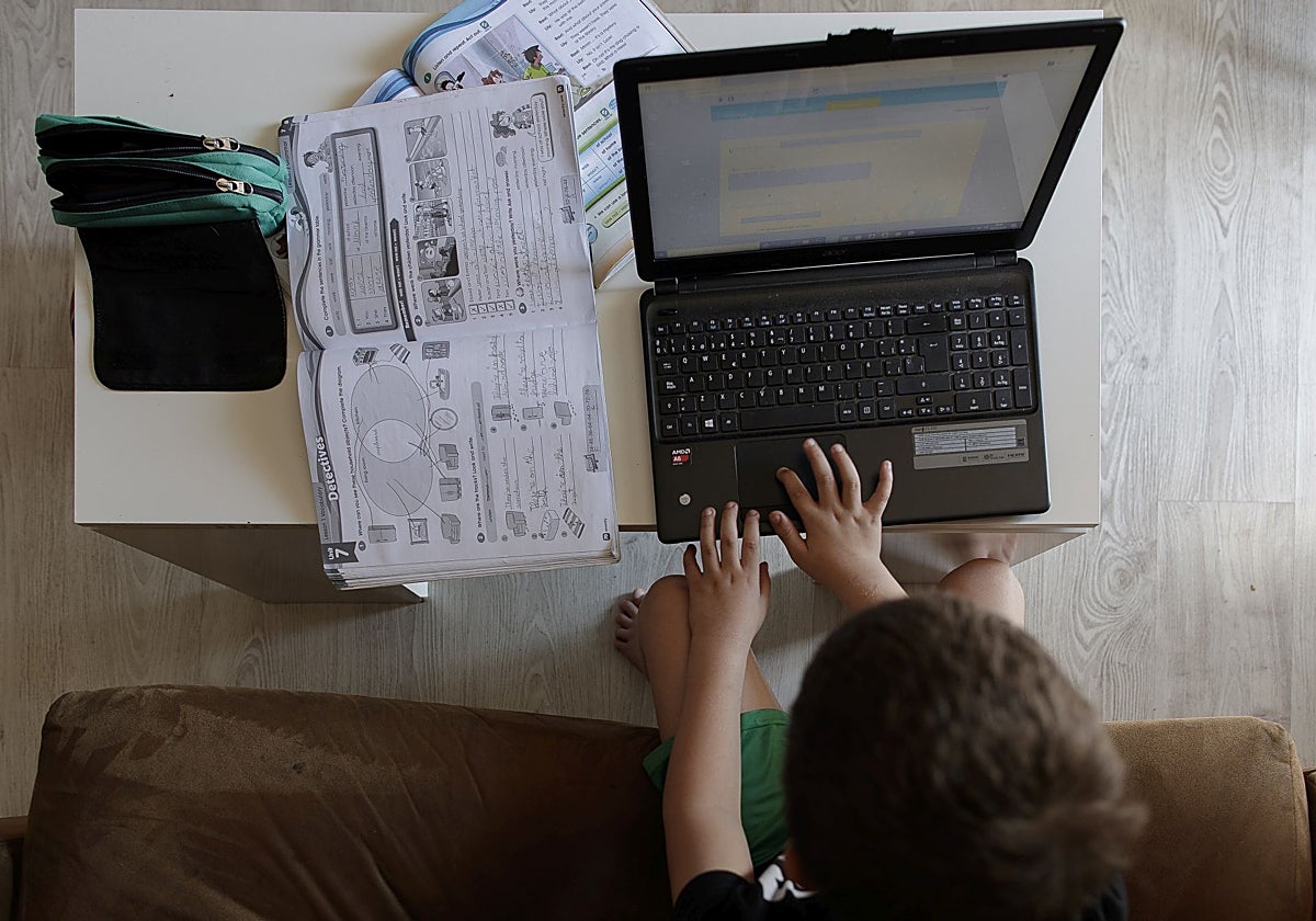 Un estudiante de primaria hace los deberes utilizando un ordenador portátil (archivo)