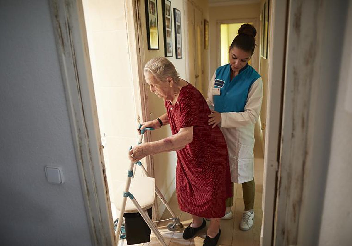 Una persona mayor con el personal contratado por la Comunidad de Madrid