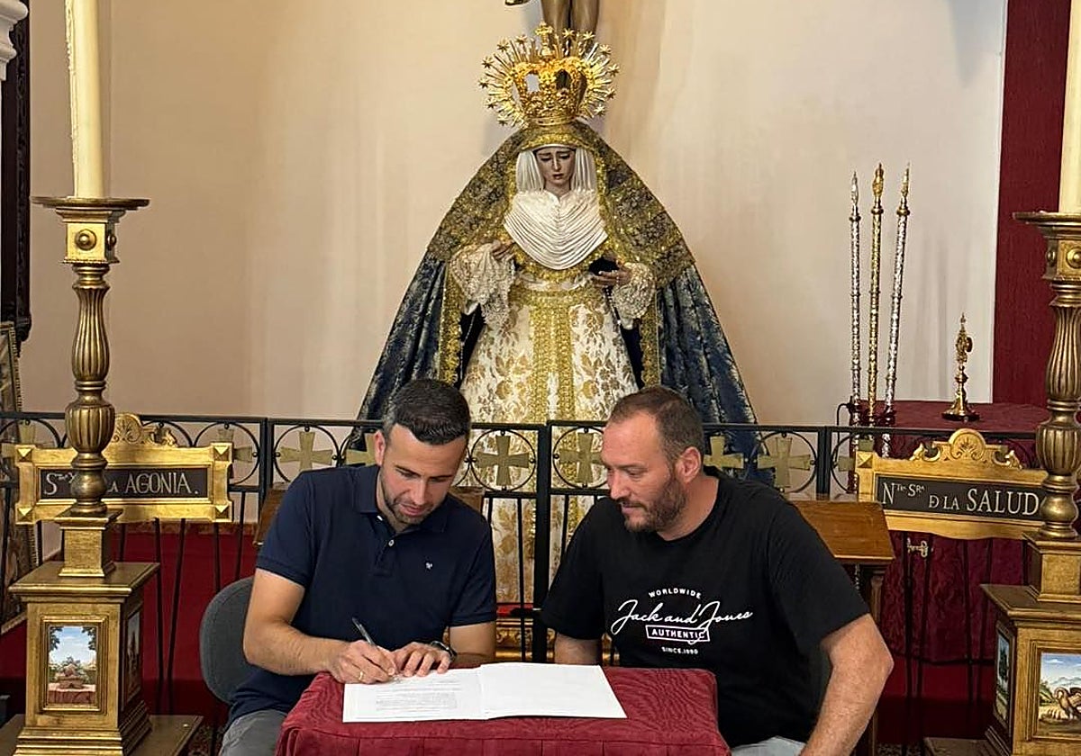 Firma del contrato entre el representante de la banda y el hermano mayor, David Carbonero, ante la Virgen de la Salud