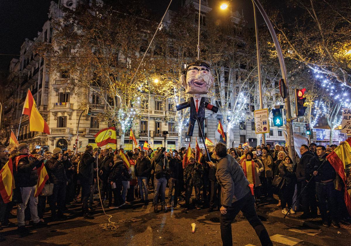 Manifestantes de Ferraz apalean una piñata con la imagen de Pedro Sánchez en Nochevieja. (Archivo)