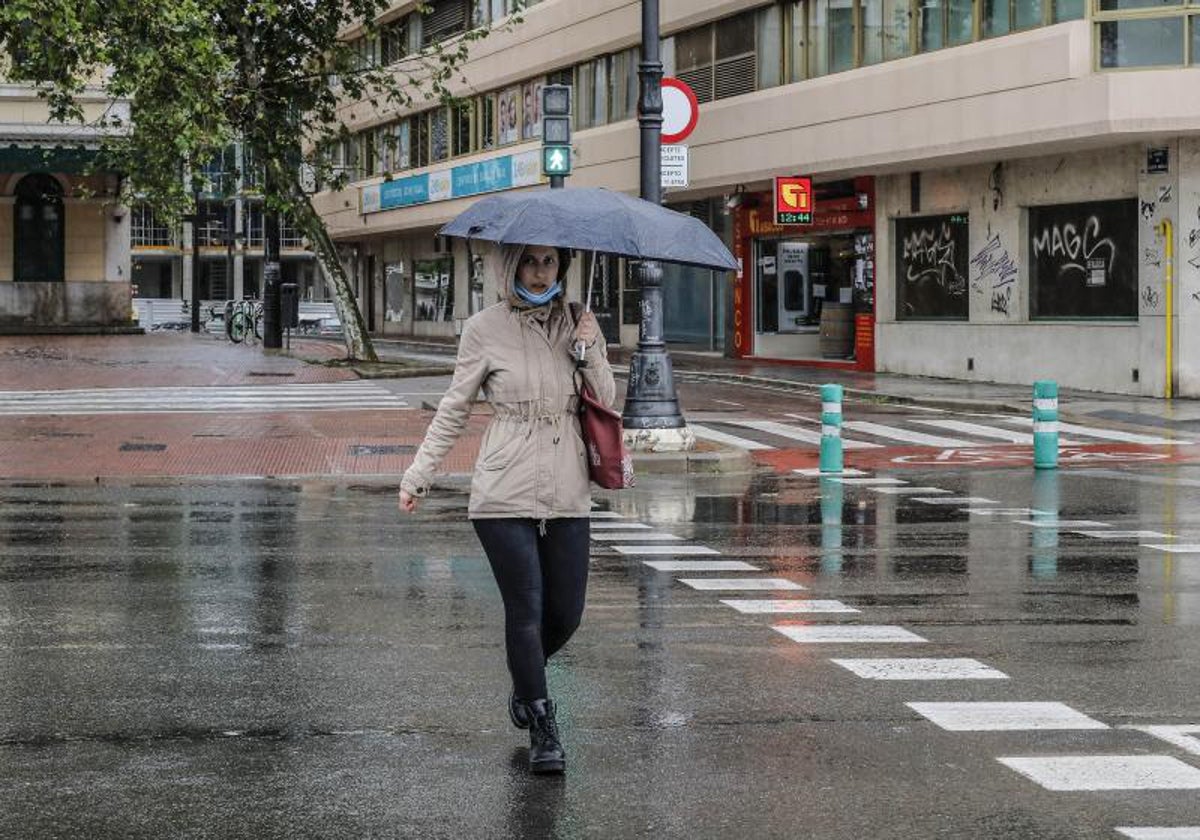 Imagen de archivo de una mujer con un paraguas en Valencia