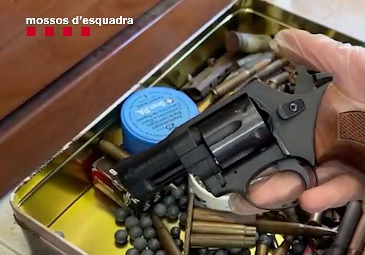 Un agente sujeta una de las armas intervenidas al traficante detenido en Tarragona