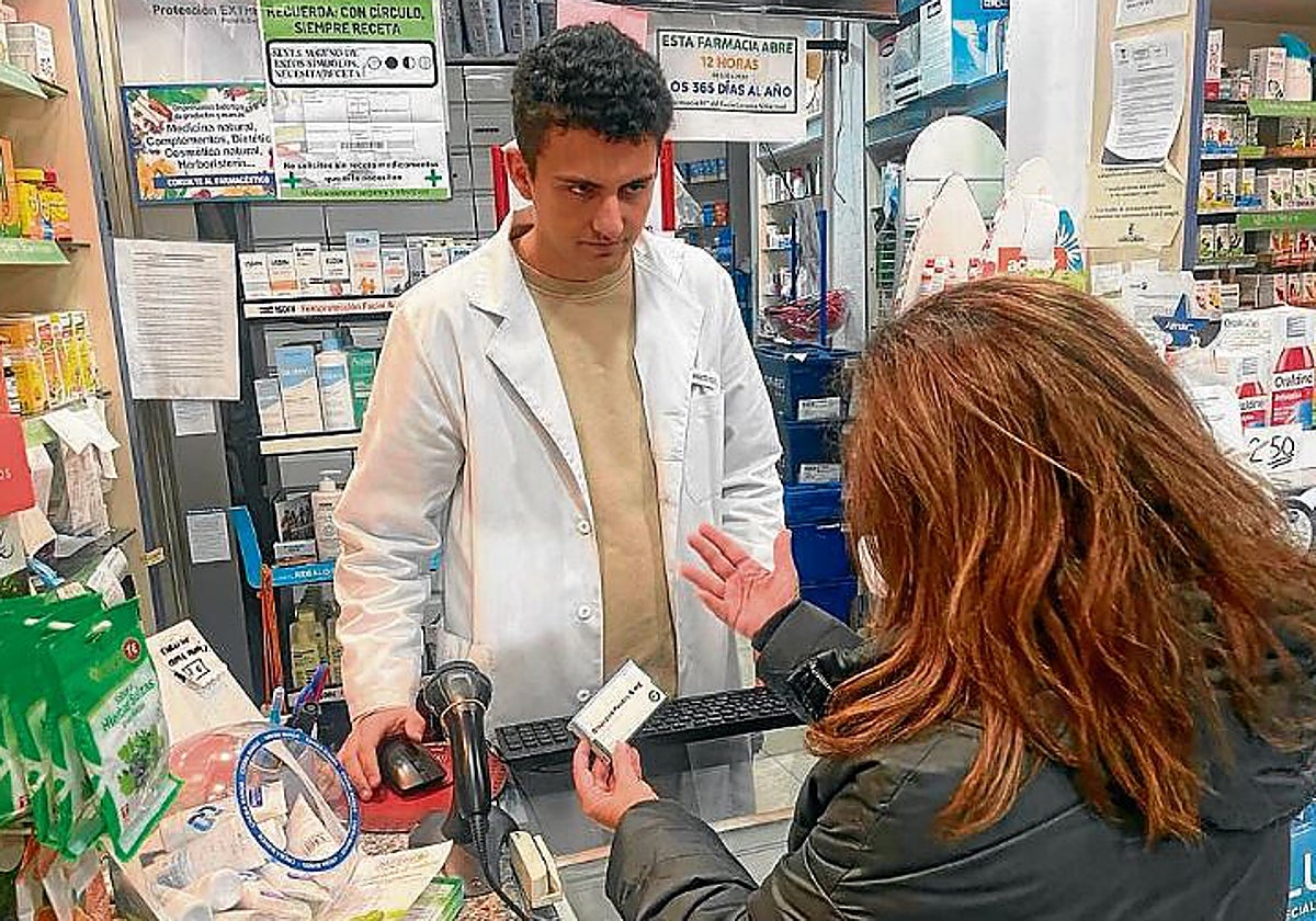 Un profesional atiende a una clienta en una farmacia de Toledo