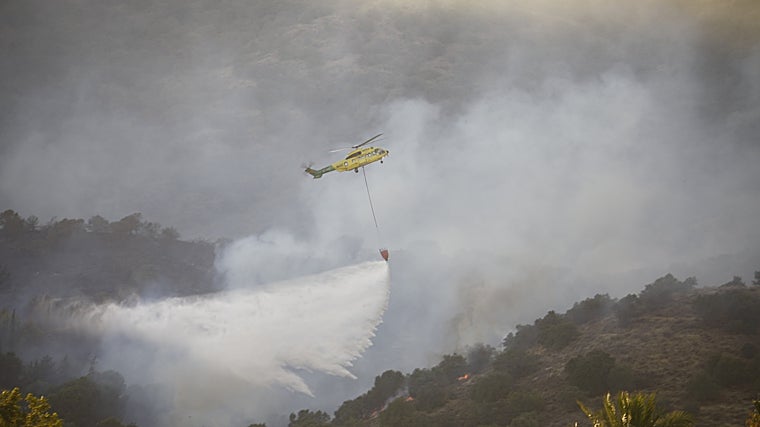 Un helicóptero evacúa agua sobre la zona del incendio