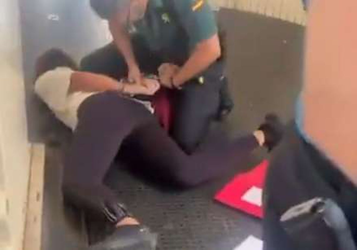 Imagen de agentes de la Guardia Civil reduciendo a la responsable del grupo en el aeropuerto de Valencia, difundidas en redes sociales