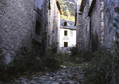 Imagen secundaria 1 - Arriba, el embalse de Lanuza donde se practican deportes náuticos. Abajo, un detalle de las calles y a la derecha, en 1985, aún por reconstruir por sus vecinos
