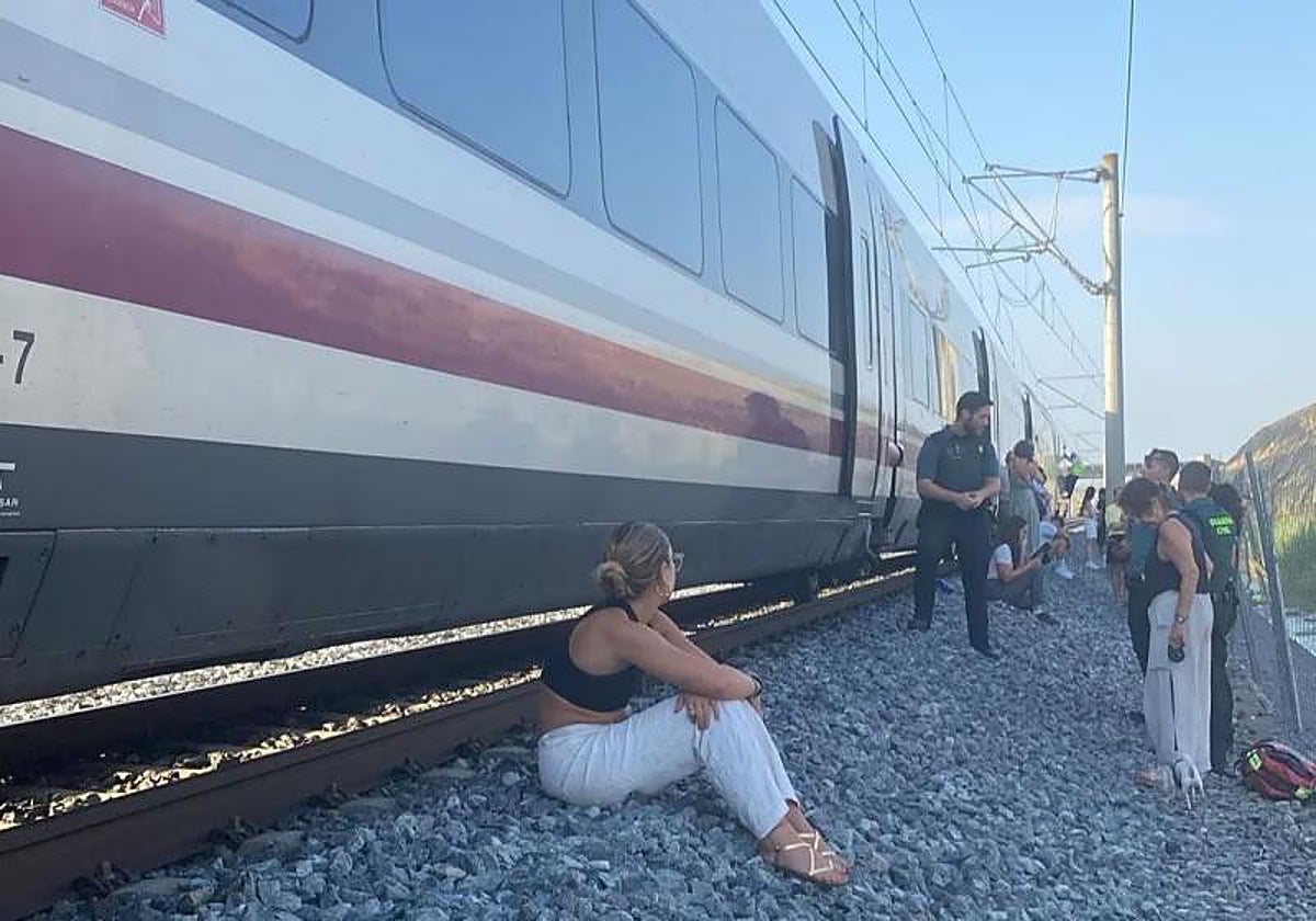 Viajeros esperando fuera del tren durante una avería