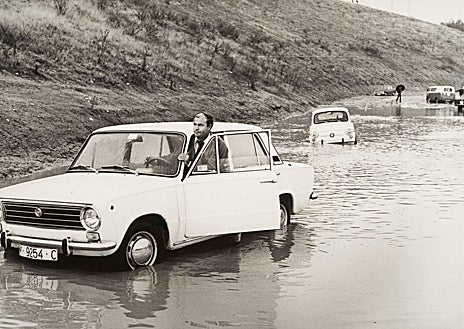 Imagen secundaria 1 - Arriba, un vehiculo intenta atravesar un vado cubierto de agua. Abajo (izq.), el conductor se ve obligado a bajar y empujar el coche. Dcha., varios peatones intentando circular entre el barrizal