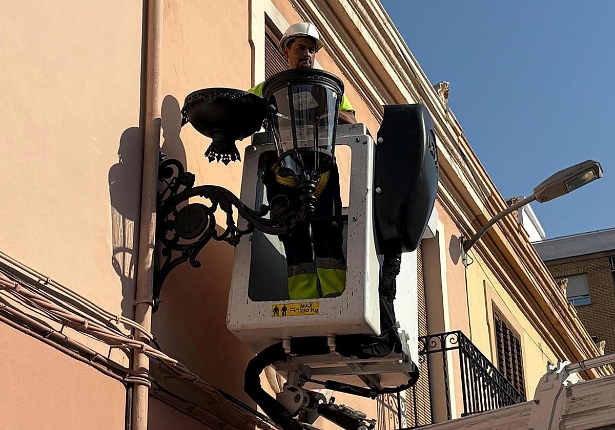 Imagen de un operario cambiando el alumbrado público en el barrio de Orriols
