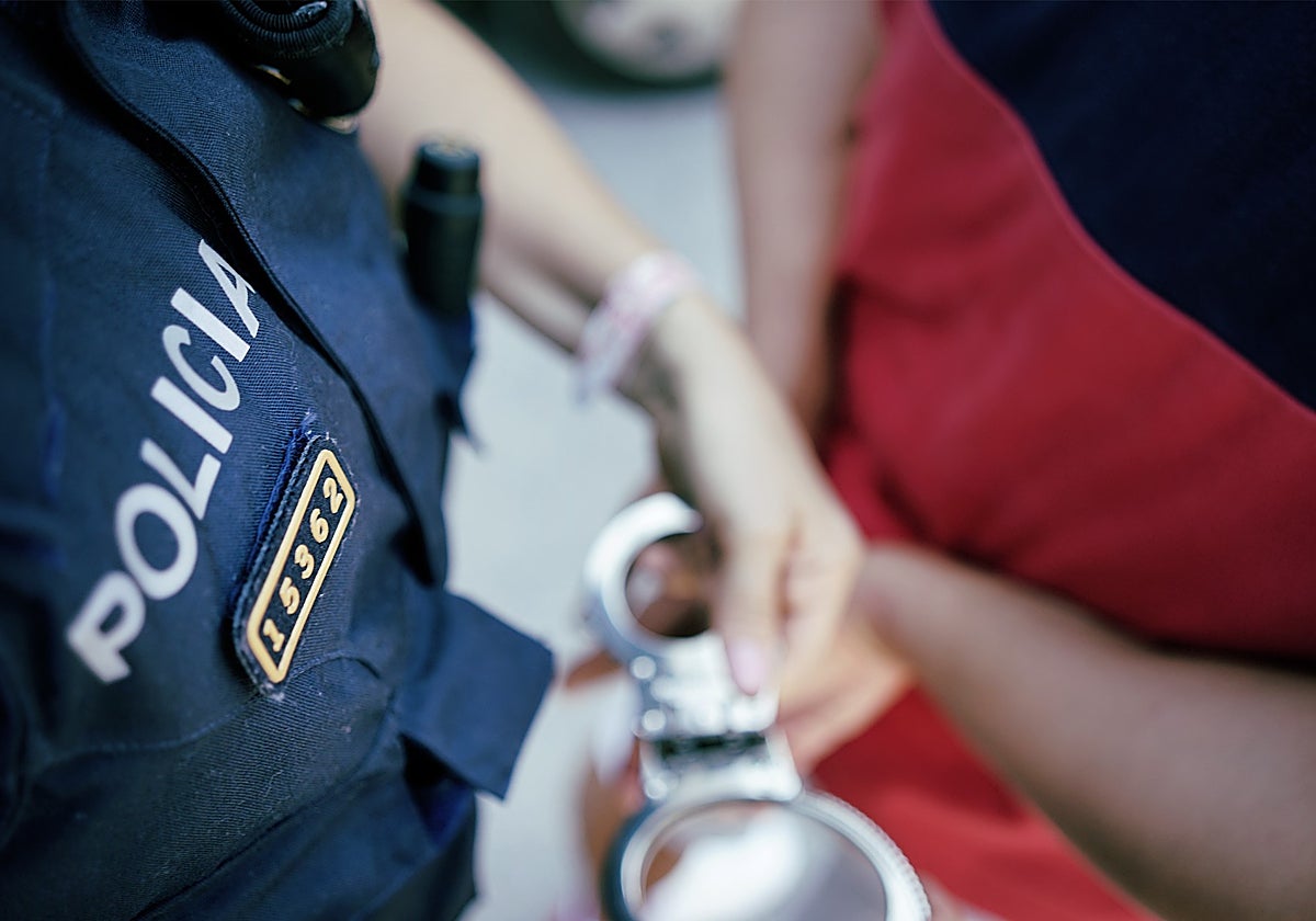 Un agente coloca las esposas a un detenido, en una imagen de archivo