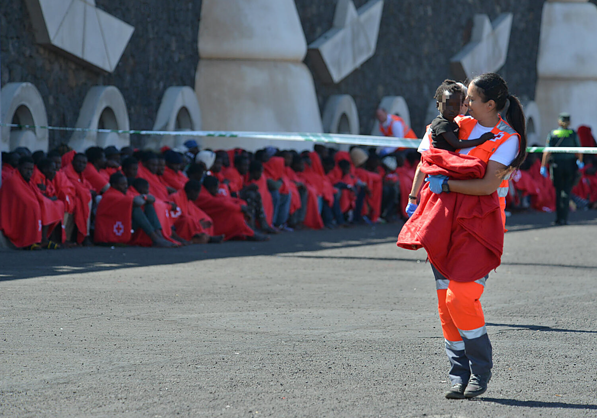 Una trabajadora de Cruz Roja atiende a un niño rescatado de un cayuco en el muelle de La Restinga, El Hierro, en foto de archivo