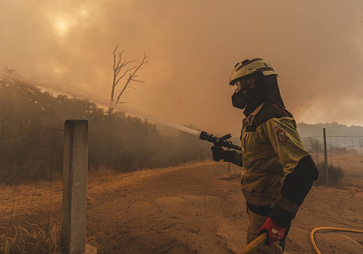 Uno de los bomberos de La Coruña, combatiendo el fuego en la explotación bovina de Simón