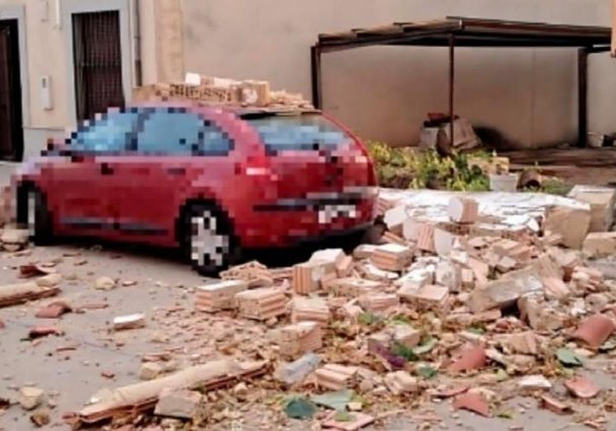 Muro caído sobre un coche este domingo por el fuerte viento