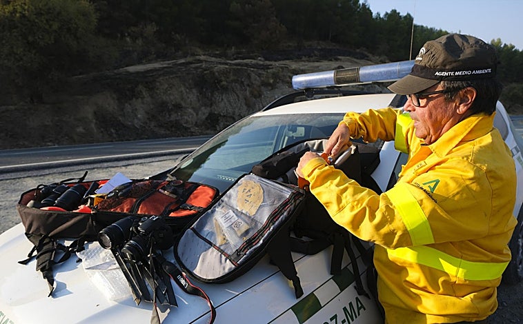 Imagen principal - Los agentes llevan en la mochila desde una pequeña estación meteorológica a testigos, banderitas o pruebas que recaban en las zonas de los incendios. 