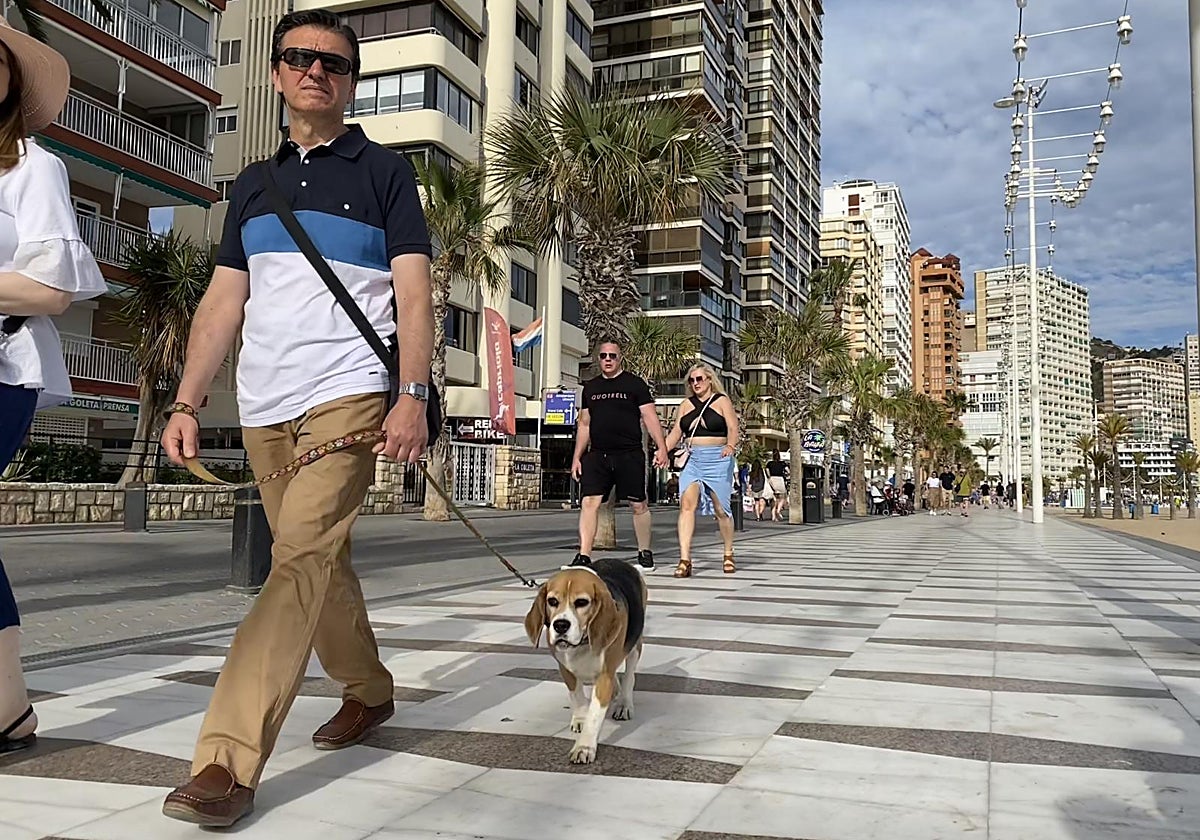 Paseantes junto a la playa de un destino turístico