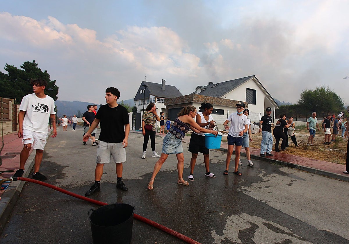 Los vecinos de Molinaseca (León) hacen una cadena con cubos de agua para frenar el incendio en la zonaI