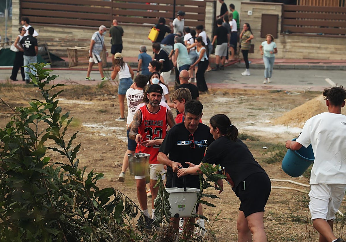 Vecinos de Molinaseca (León) hacen una cadena con cubos de agua para evitar que el fuego alcance sus casas