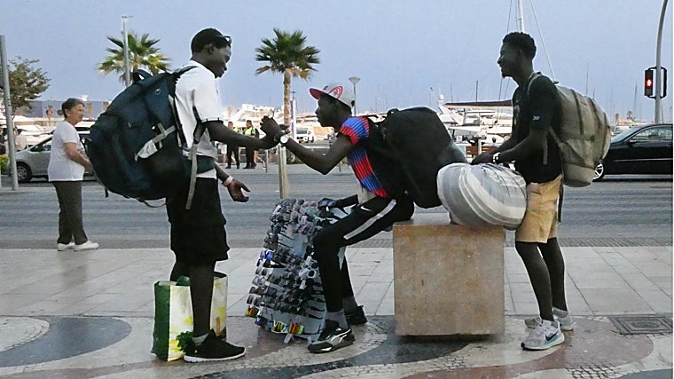 Varios 'manteros', cargados con sus mercancías