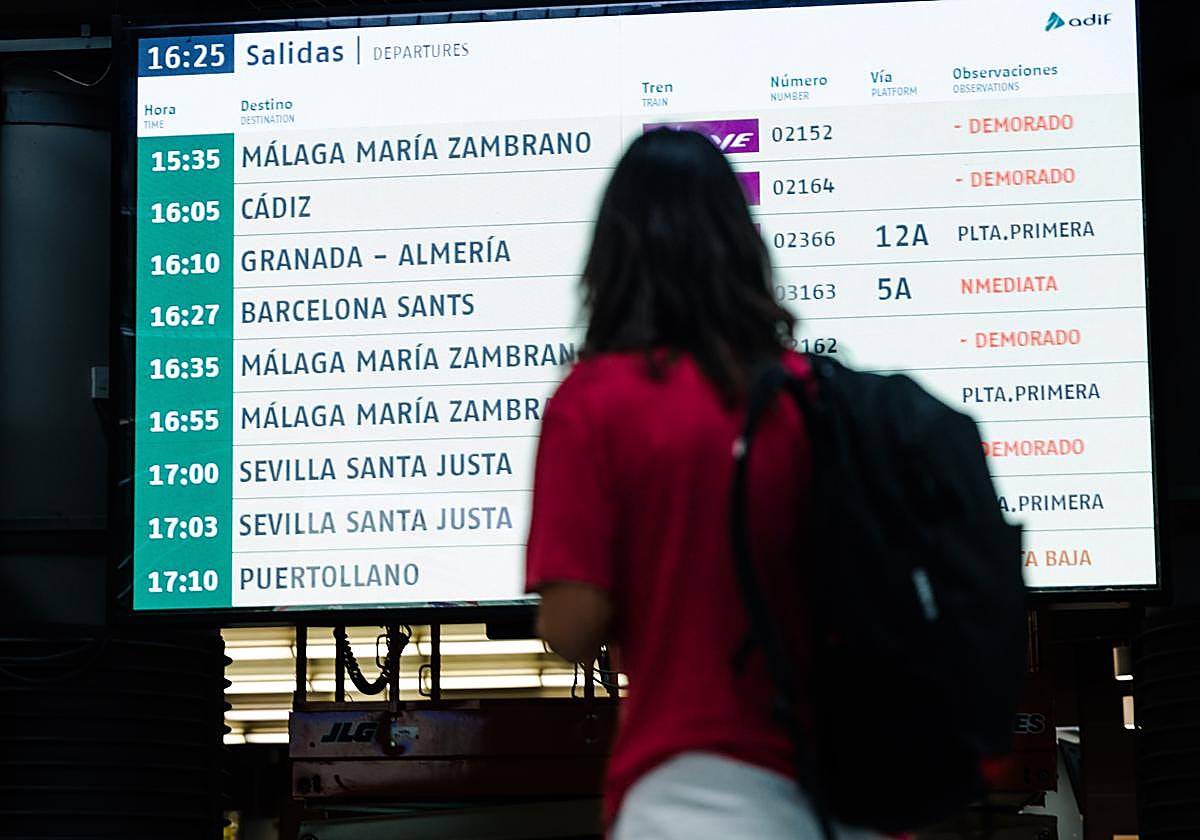 Una persona observa una pantalla informativa en la Estación de Madrid - Puerta de Atocha - Almudena Grandes, a 30 de agosto de 2025, en Madrid (España)