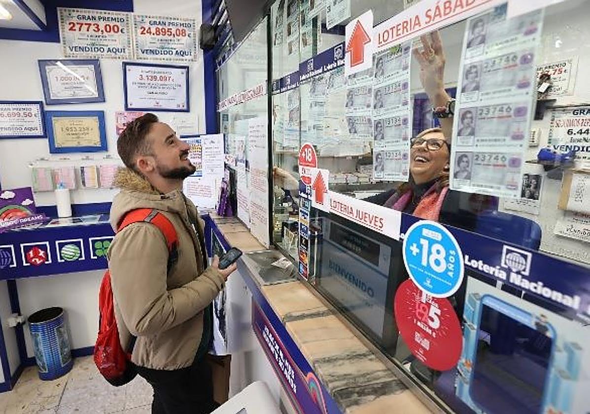Un joven comprando lotería en una administración