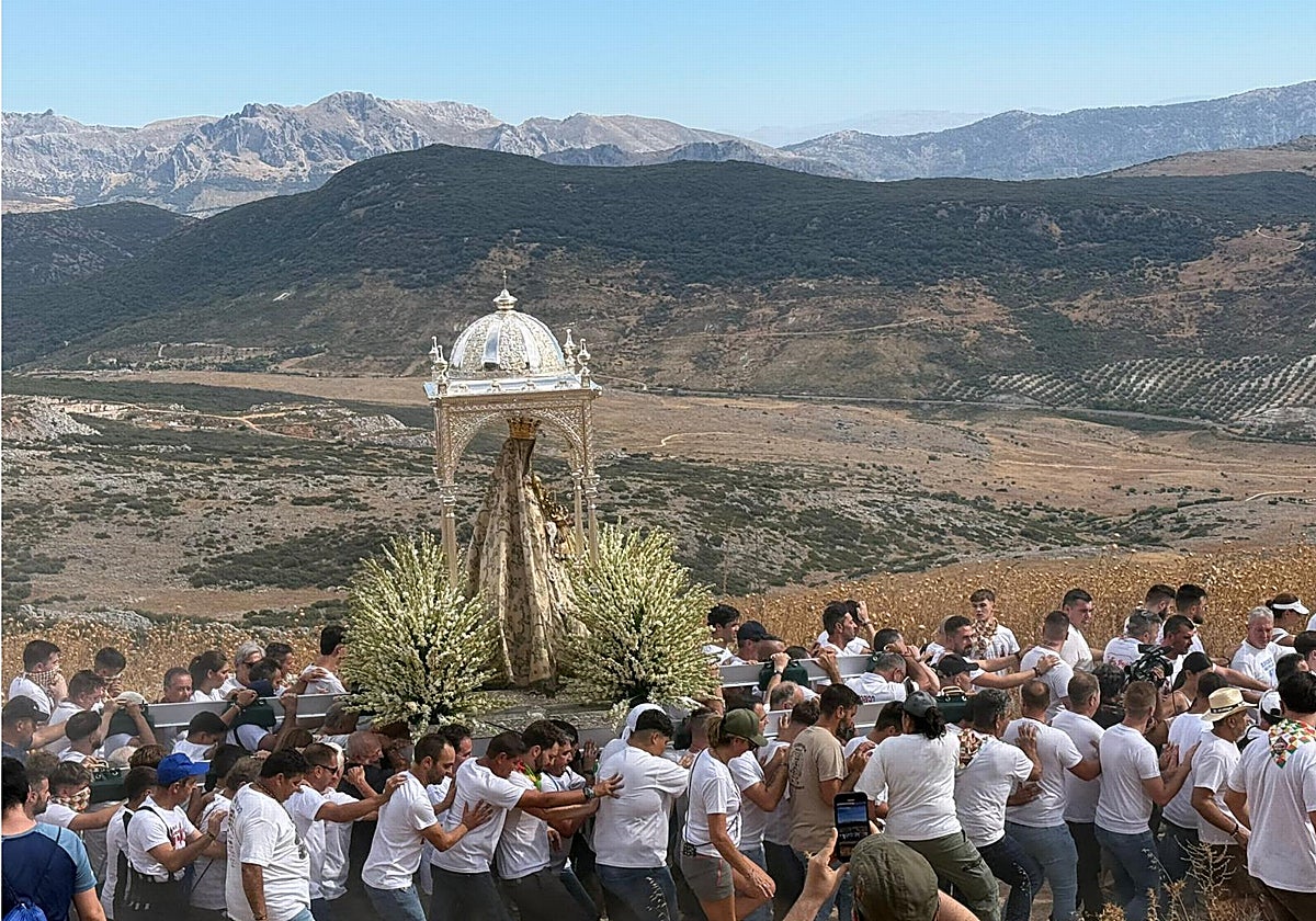 Los costaleros llevan a la Virgen de la Sierra por las primeras pendientes y con las Sierras Subbéticas al fondo