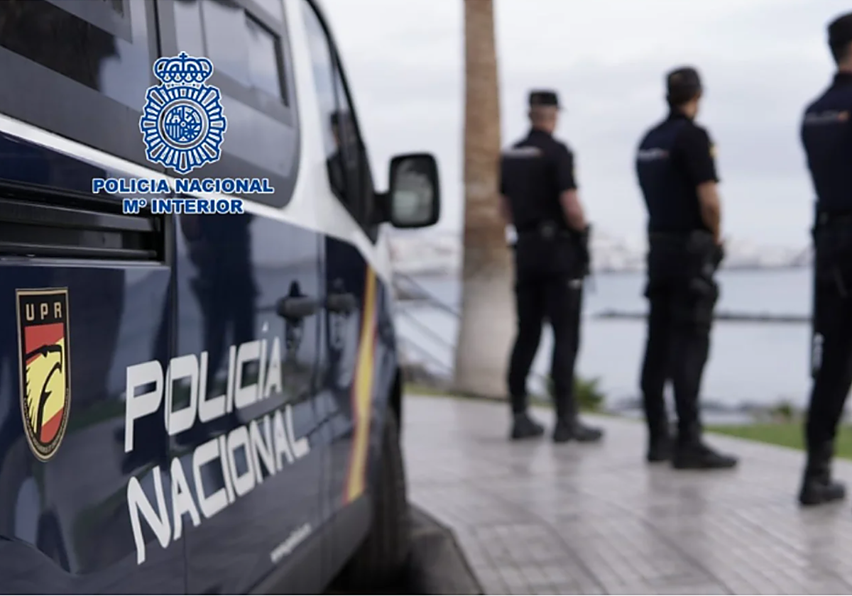 Agentes de la Policía Nacional y vehículo policial en foto de archivo