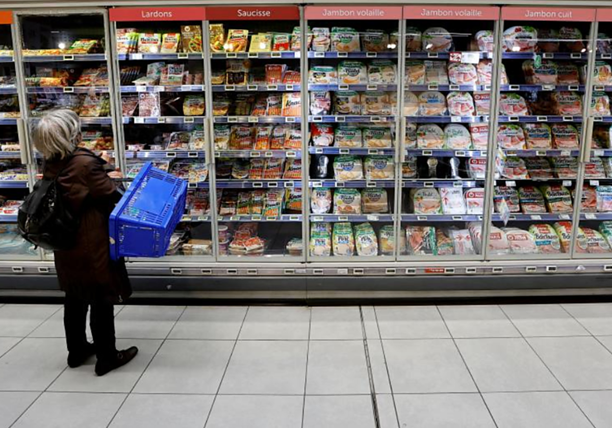 Una mujer compra en un supermercado en foto de archivo
