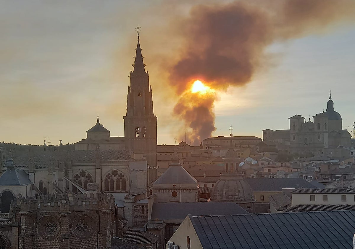 El intenso humo se confunde con la puesta de sol en Toledo desde la zona del Alcázar