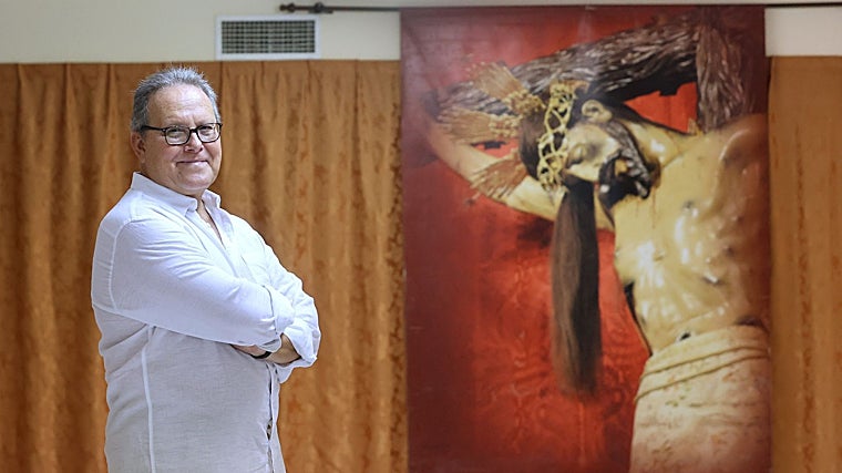 José María Gisbert, junto a una fotografía del Cristo de Gracia, en la casa de hermandad