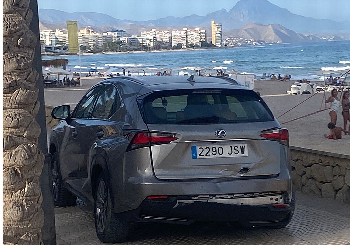 El coche encima de la acera y entre el murete del paseo marítimo de El Campello y una palmera, tras estrellarse