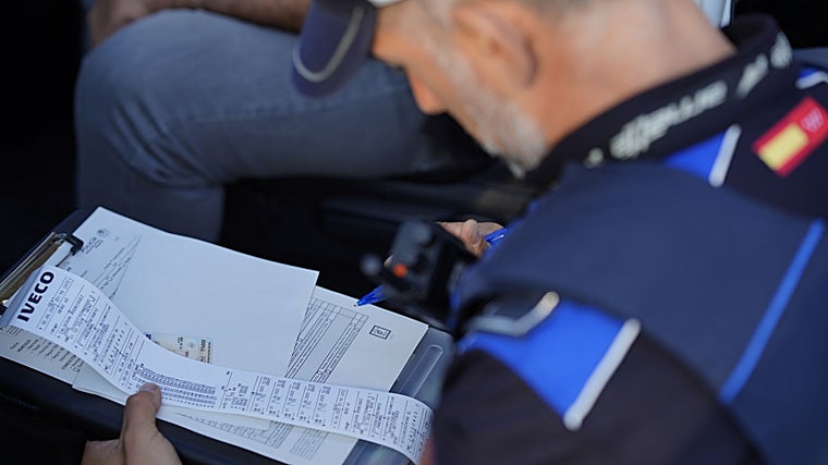 Uno de los agentes revisa la documentación de un vehículo escolar