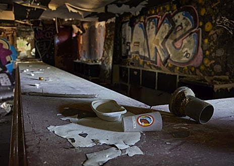 Imagen secundaria 1 - Vista general desde la azotea del viejo burdel, copada por la escombrera ilegal y el paso de vehículos en la A-5; la antigua barra del club de alterne, con algunos vasos de la época; y varias tarjetas de visita de Las Vegas Deluxe tiradas por el suelo