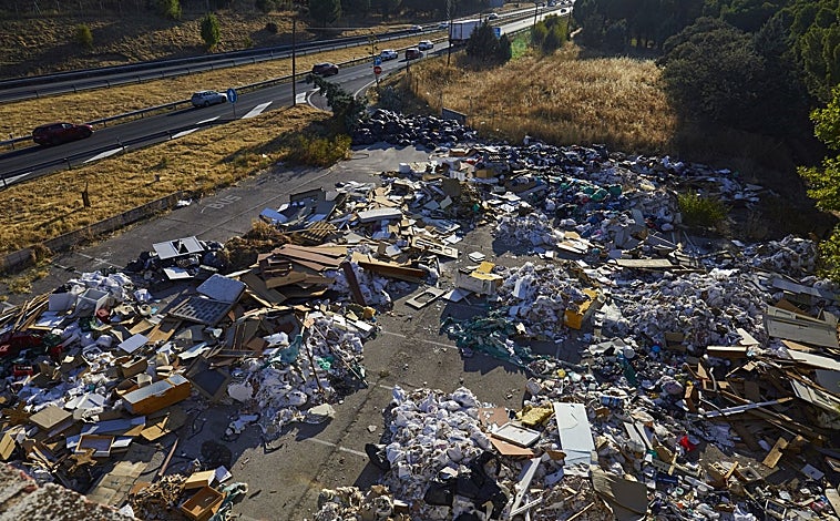 Imagen principal - Vista general desde la azotea del viejo burdel, copada por la escombrera ilegal y el paso de vehículos en la A-5; la antigua barra del club de alterne, con algunos vasos de la época; y varias tarjetas de visita de Las Vegas Deluxe tiradas por el suelo
