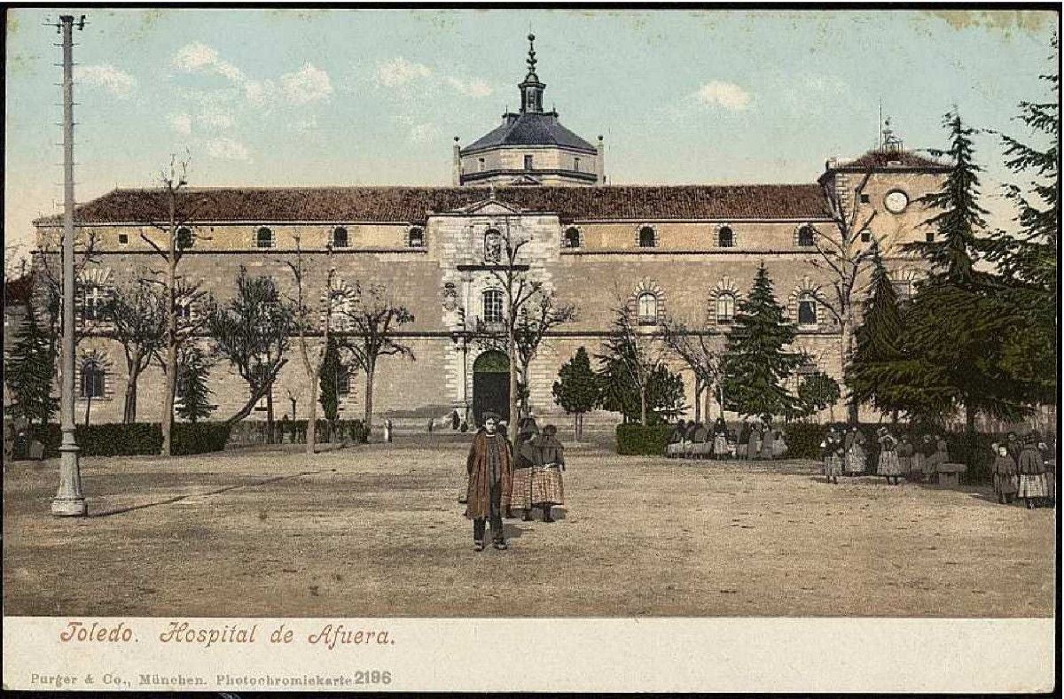 Un grupo de niñas juegan en el paseo central de Merchán. Al fondo, el Hospital de Tavera hacia 1903. Tarjeta portal editada por Purger & Co., München. Archivo Municipal de Toledo