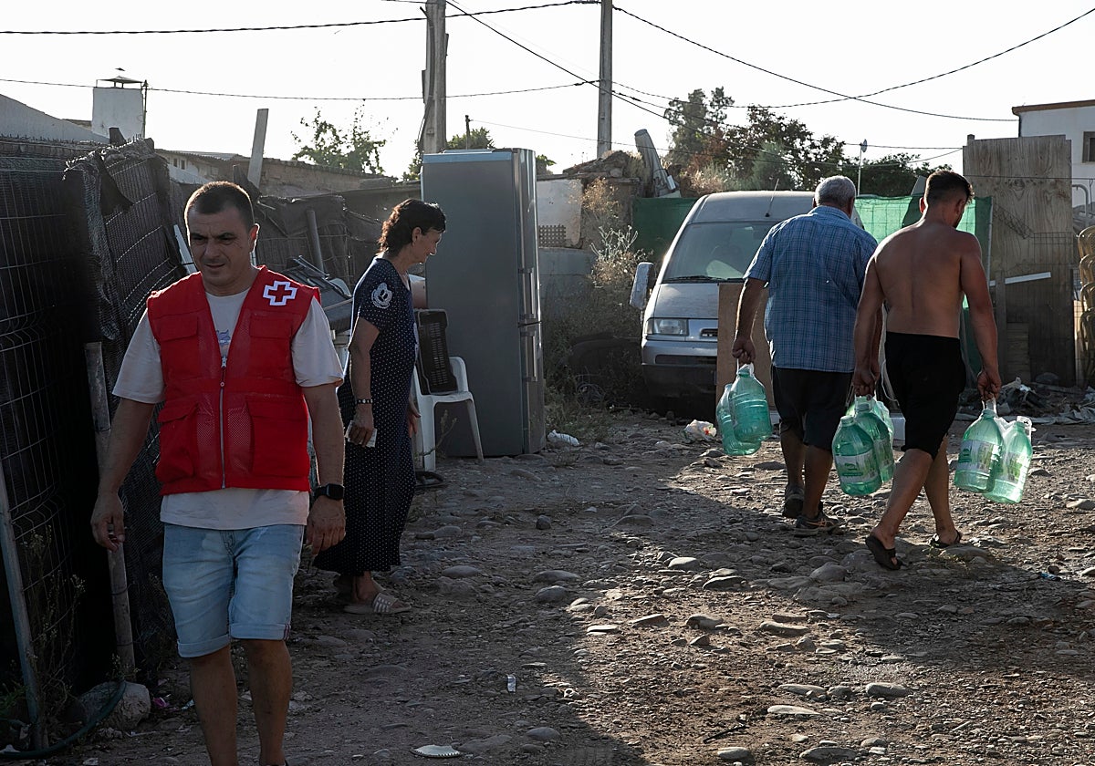Reparto de agua de los voluntarios de Cruz Roja esta semana en el asentamiento de Las Quemadillas