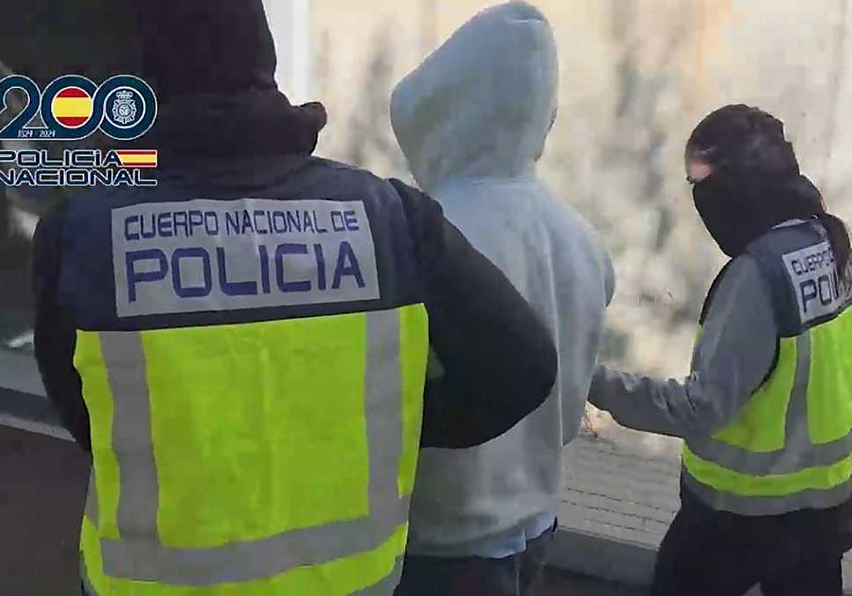 Agentes de la Policía Nacional junto a uno de los detenidos