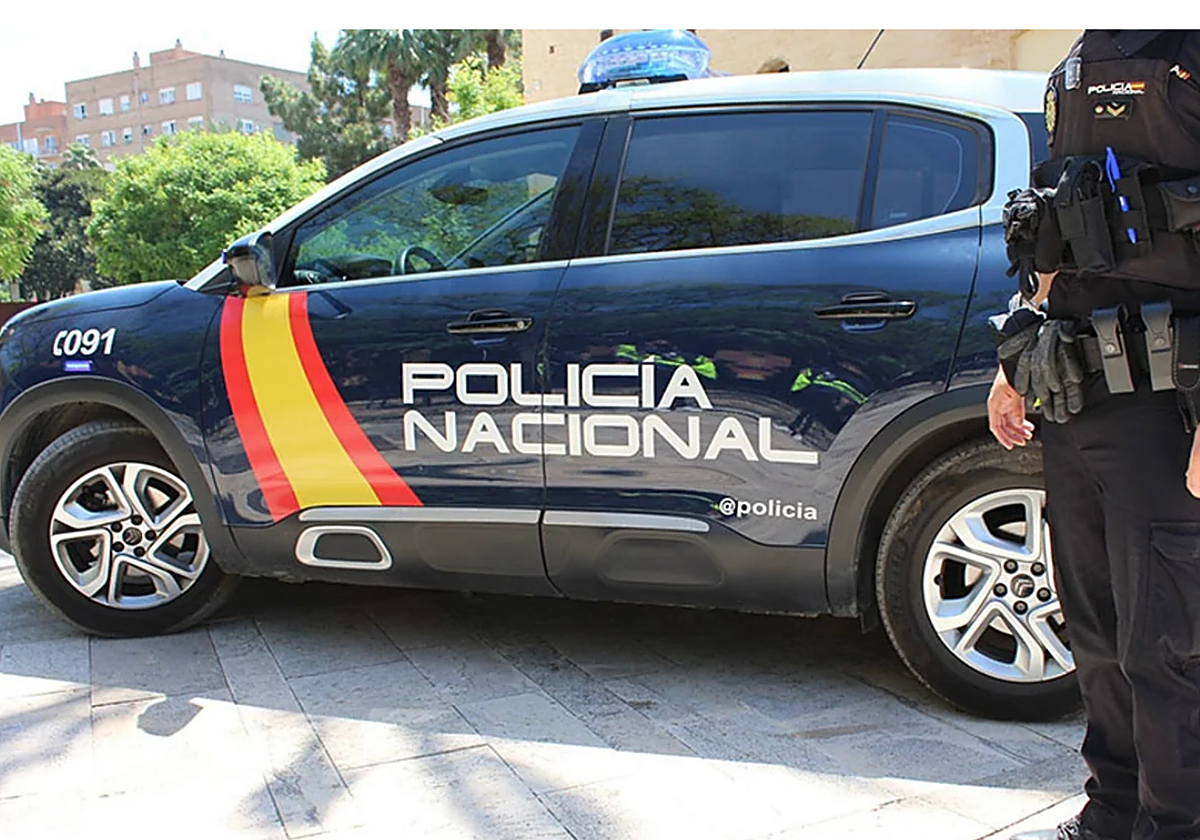 Un agente de Policía con su vehículo