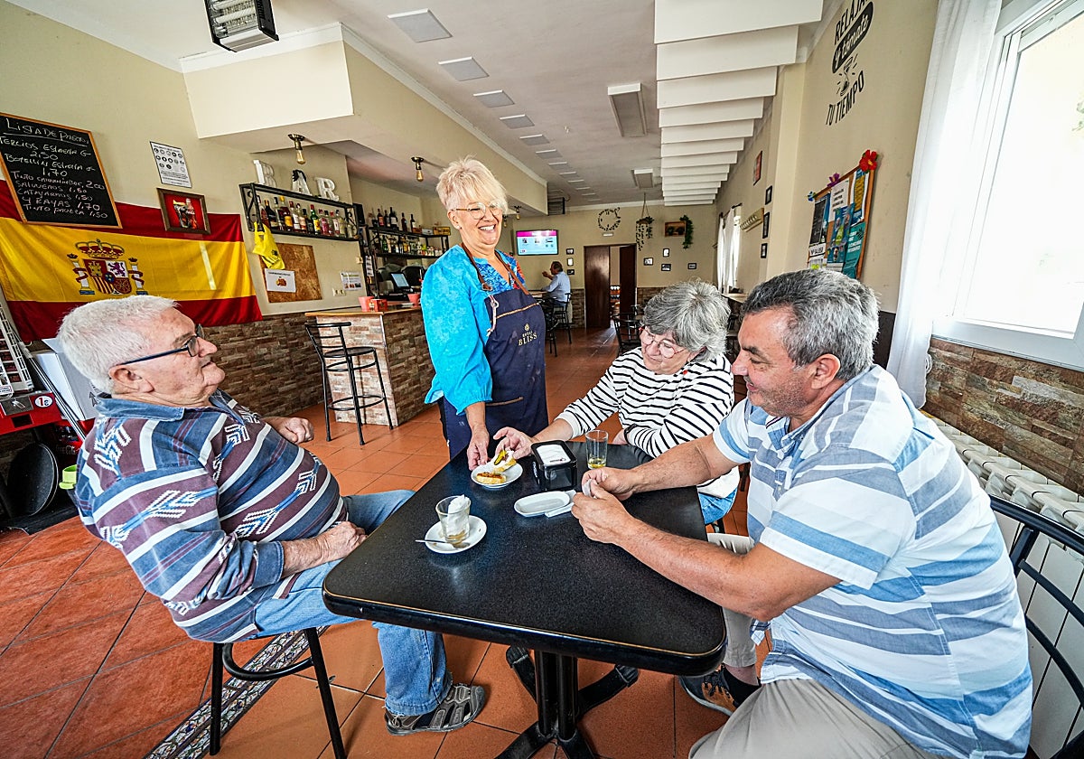 Cuqui, en el bar de Quintanilla de Trigueros (Valladolid), sirve las tapas a Rocío, Julián y Teodoro