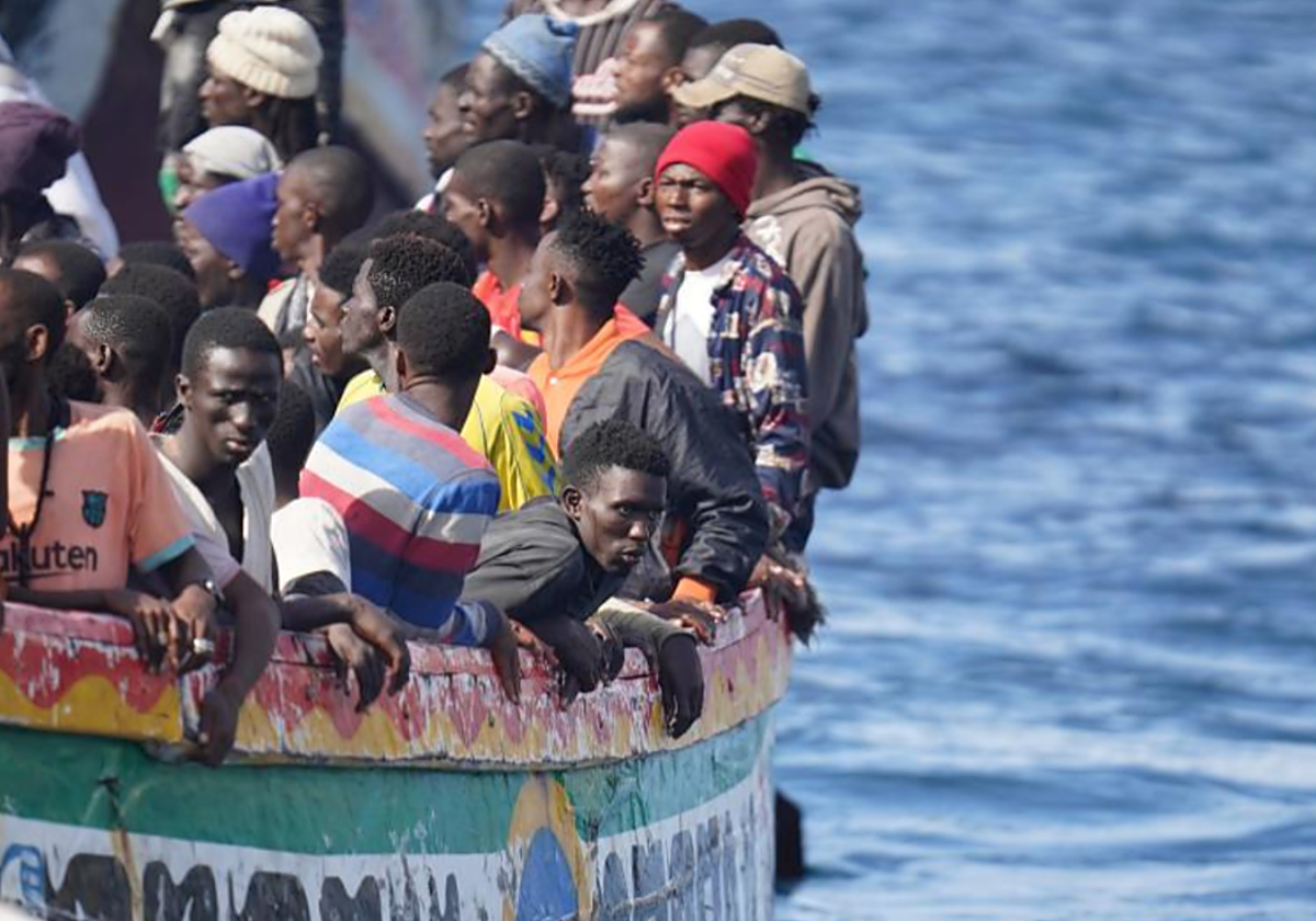 Los migrantes de un cayuco se asoman por la borda en La Restinga, en octubre de 2023