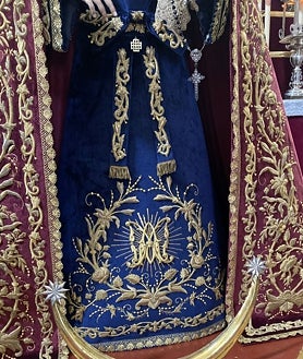 Imagen secundaria 2 - En la imagen superior, altar del triduo en honor de la Virgen del Desconsuelo. Debajo a la izquierda, detalle del manto de estreno. A la derecha, en primer plano la saya azul, con el Ave María 