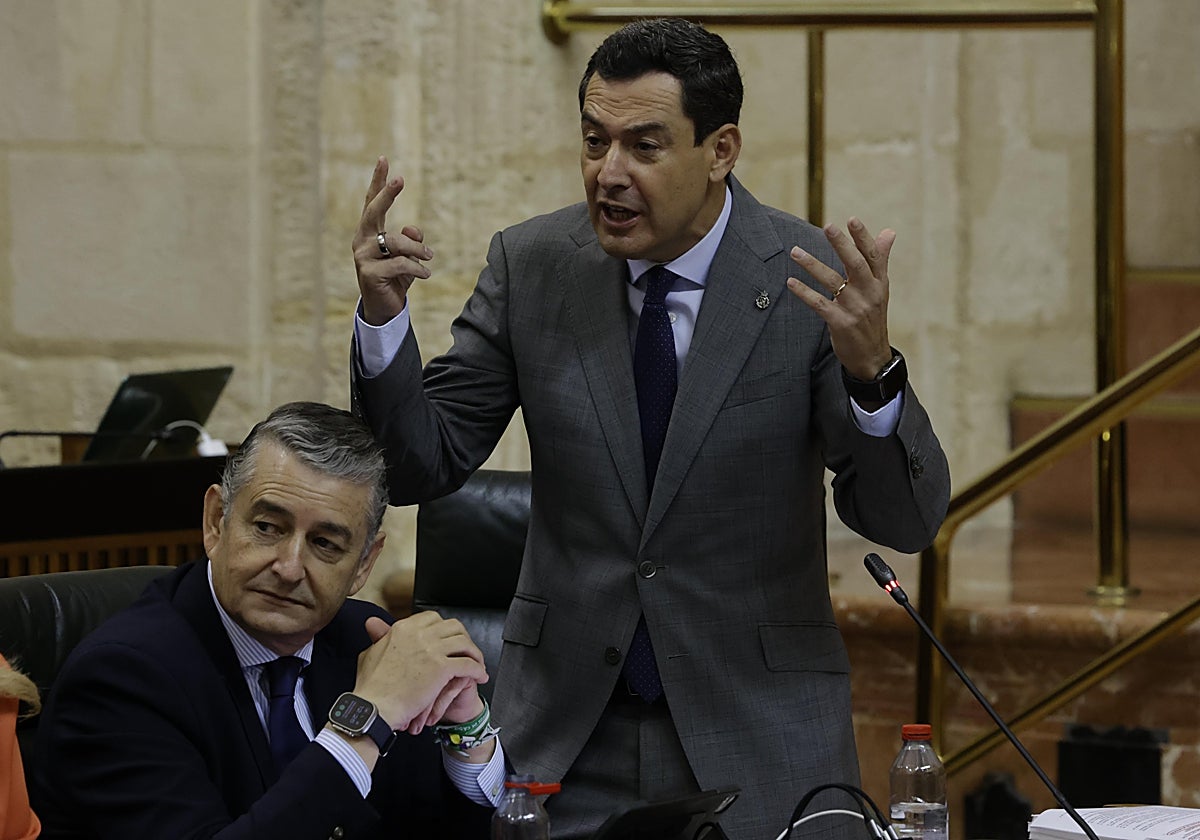 Juanma Moreno, gesticulante junto a Antonio Sanz en el Parlamento