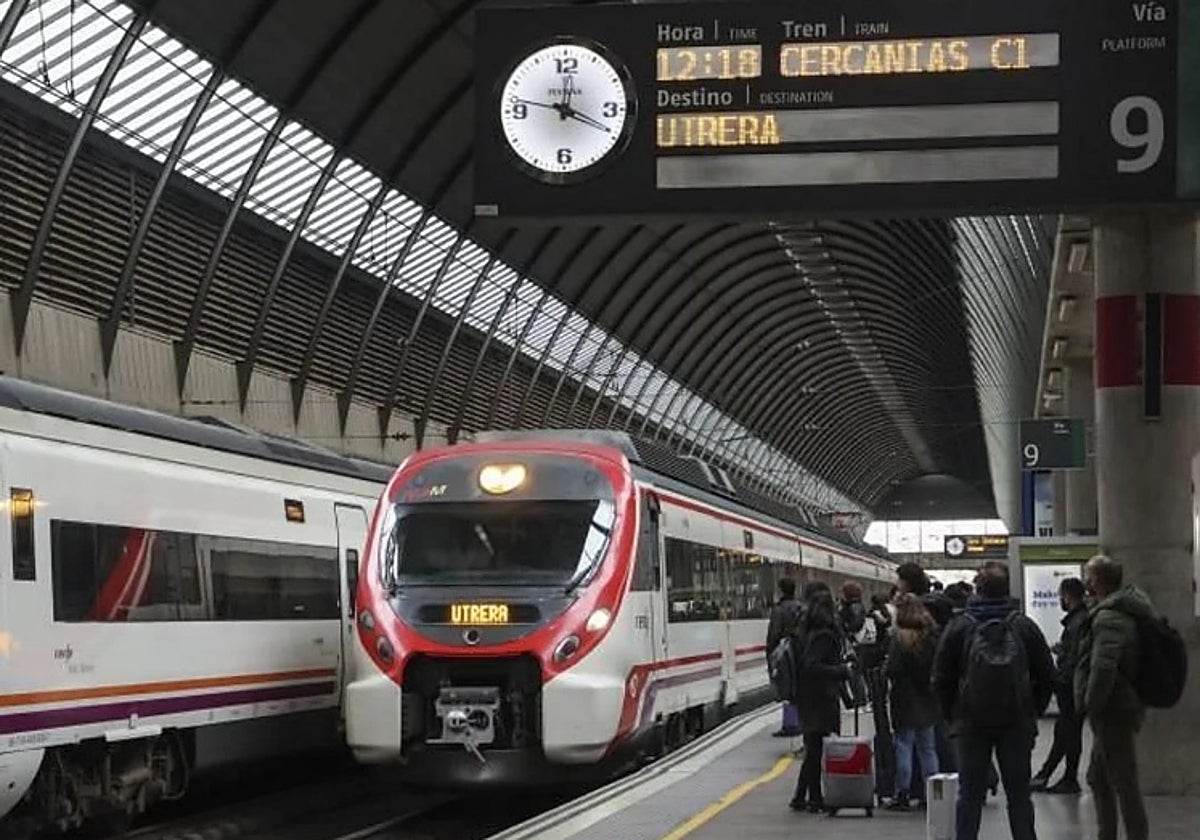 Viajeros esperan un tren de Cercanías en Santa Justa