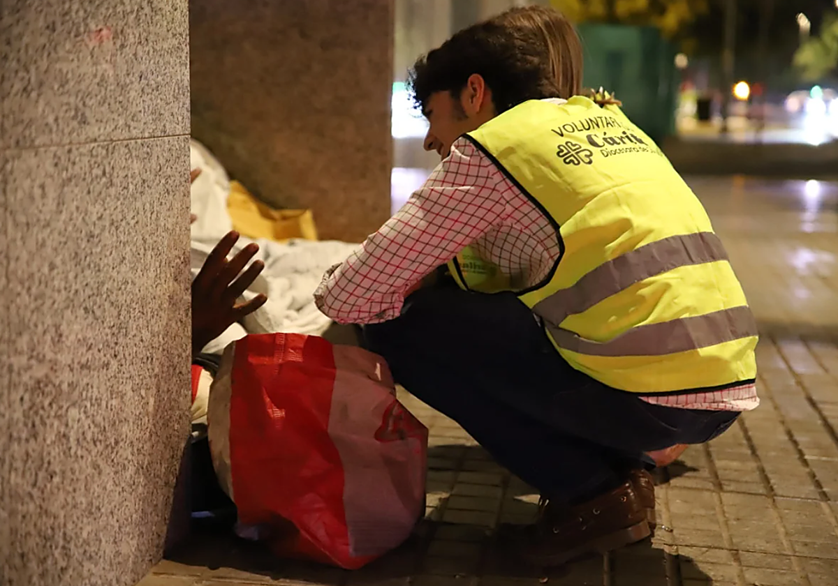 Voluntarios de Cáritas ayudando a una persona sin hogar