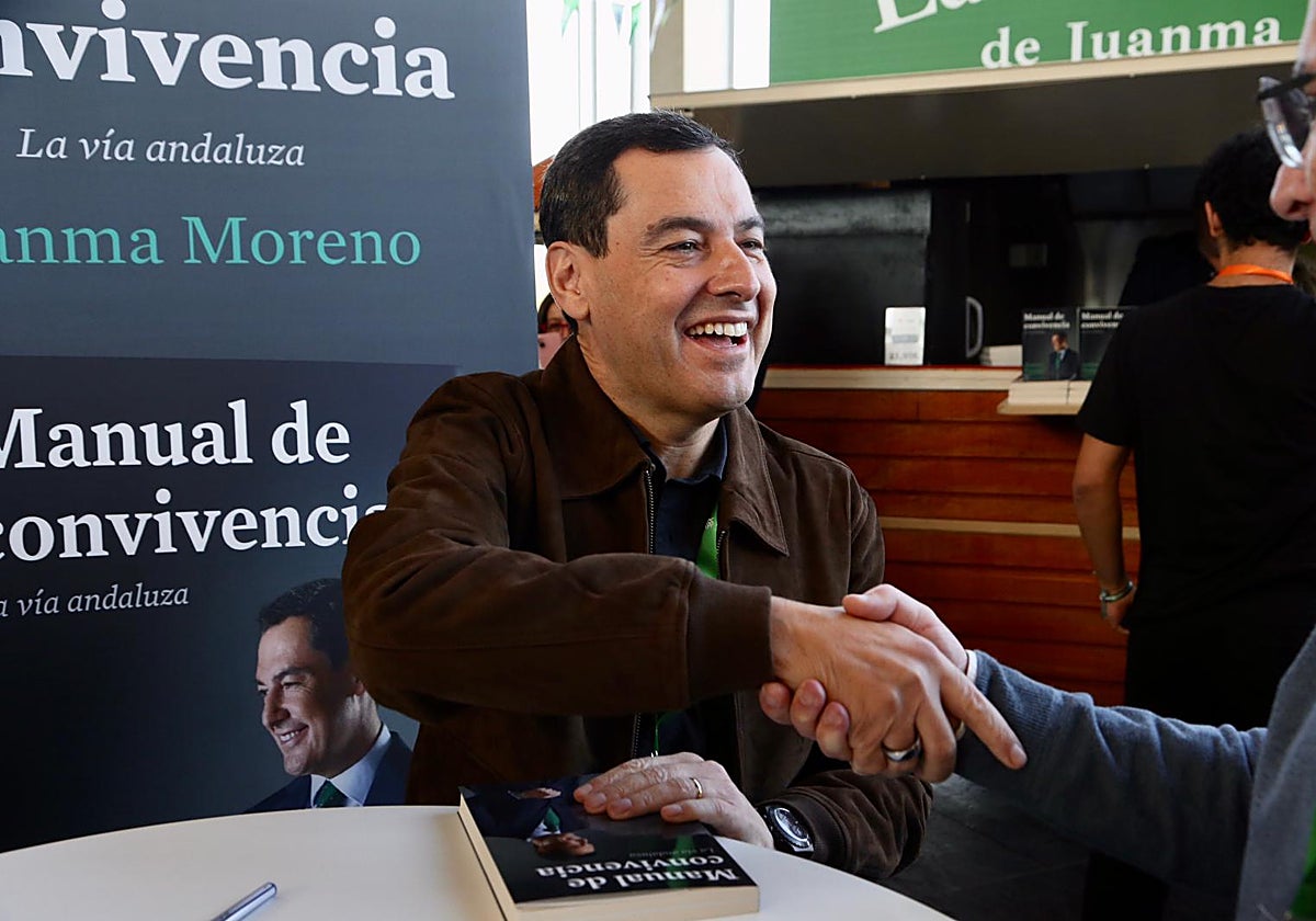 Juanma Moreno firmando ejemplares de su libro en el stand de Fibes