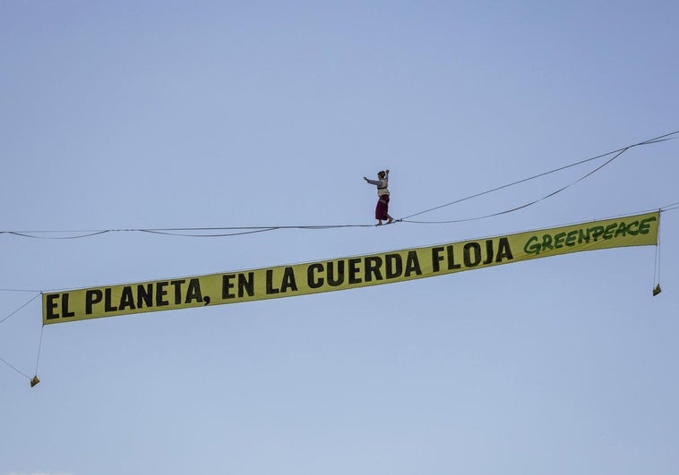 A tightrope walker walks between two buildings at the Plaza de España in Madrid to protest the climate crisis