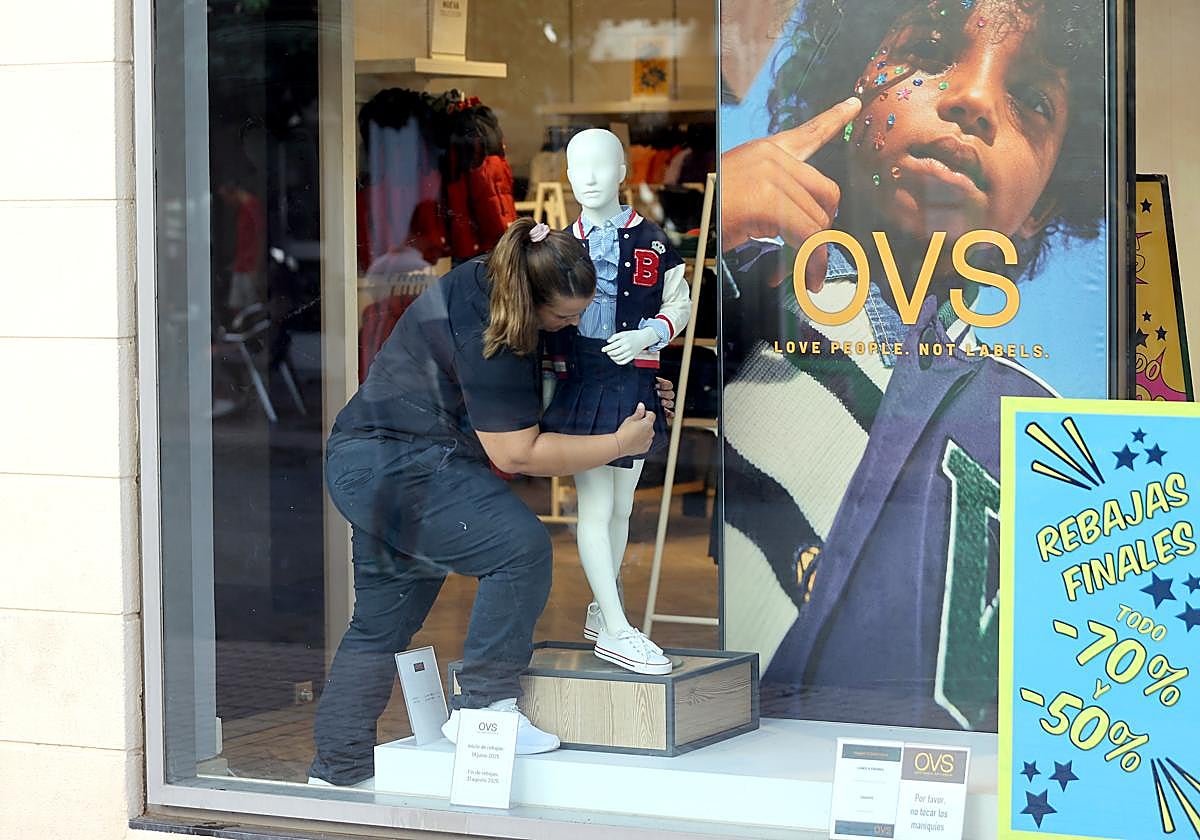 Una trabajadora prepara un escaparate en una tienda de la Viñuela